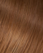 A swatch of Veronica's straight, dark golden blonde hair extension, showcasing its smooth texture and shine.