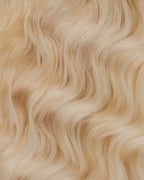 A swatch of a wavy, night golden blonde wig, showcasing its soft texture and vibrant color.