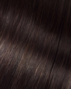 A swatch of Sally's straight, dark brown hair extension, showcasing its smooth texture and rich color.