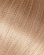 A swatch of light beige Dixie blonde hair extensions, showcasing fine, wavy texture and natural shine.