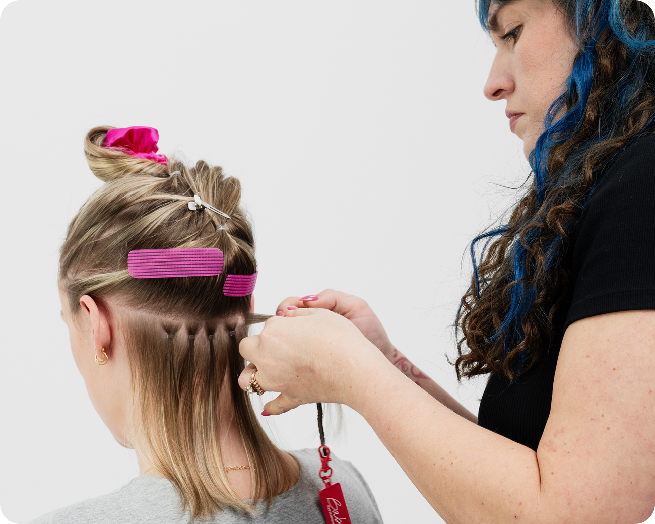 A hair stylist installing Babe beaded hair extensions into a client's hair using Babe hair assesories.