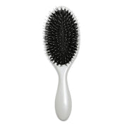 A white and black hair extension brush resting on a white surface.